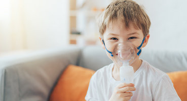 Smiling boy wearing nebulizer mask in respiratory counselling
